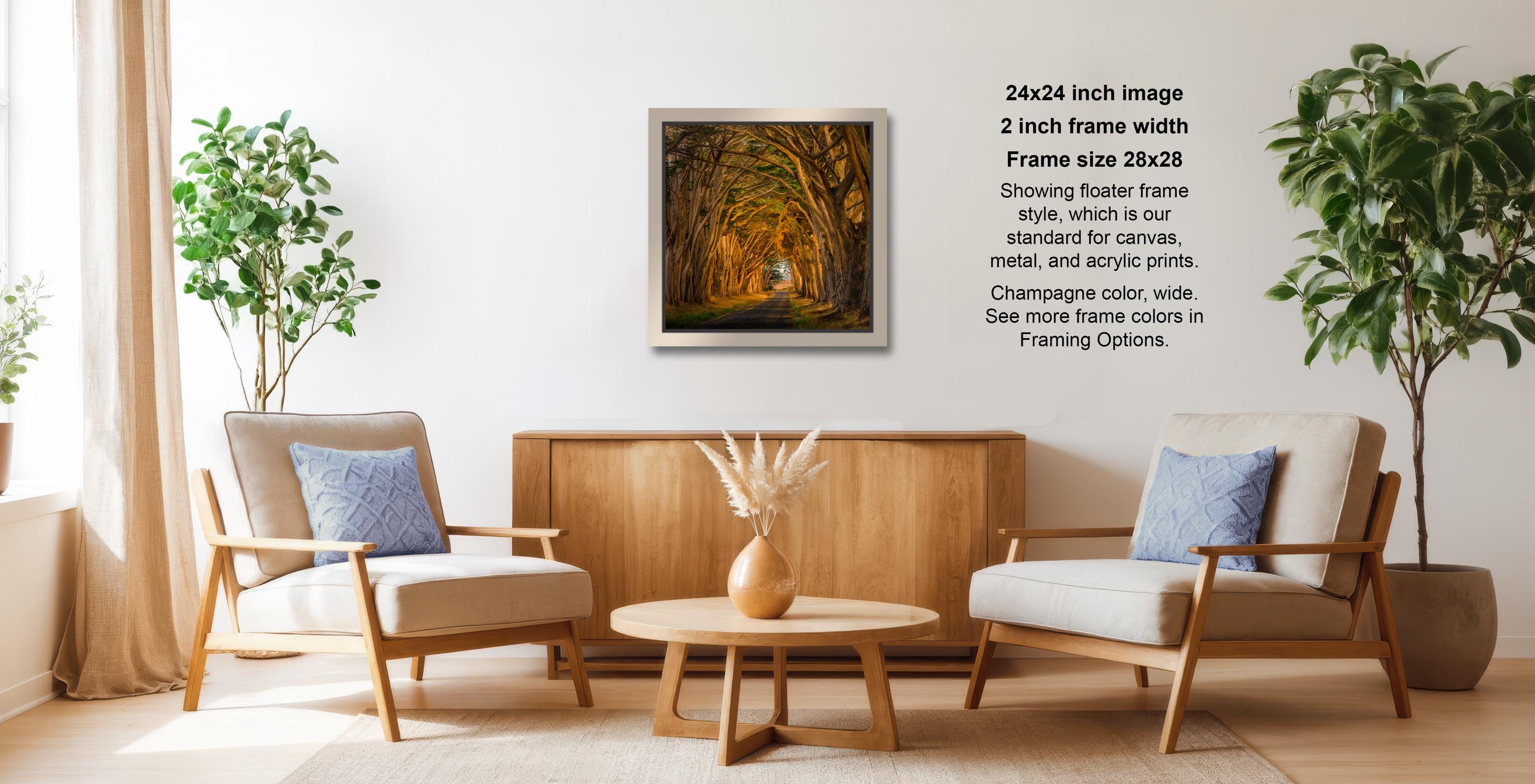 a cozy living room with two beige armchairs, a wooden coffee table, and a framed landscape photograph hanging on the wall.