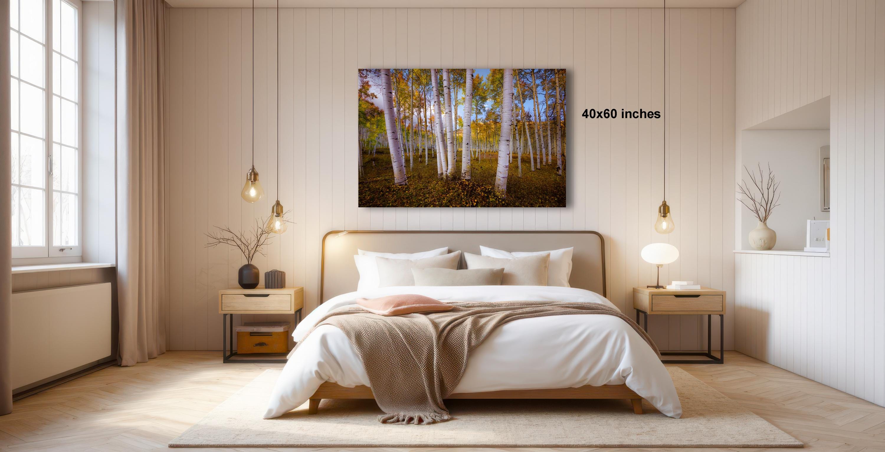 a serene bedroom with a large bed, wooden furniture, and a painting of a forest scene hanging on the wall.