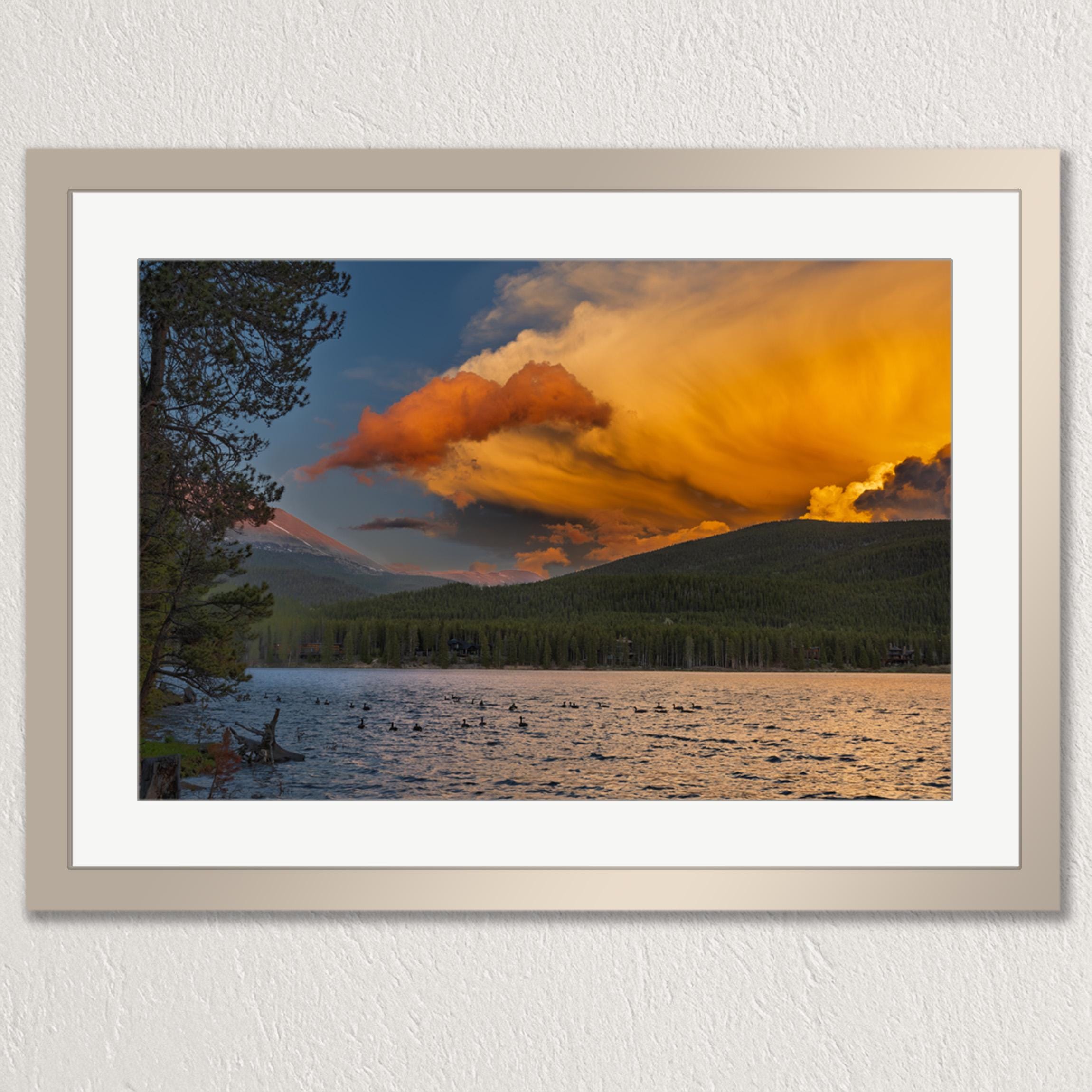 a serene lake surrounded by mountains, with a stunning sunset casting a warm glow over the scene.