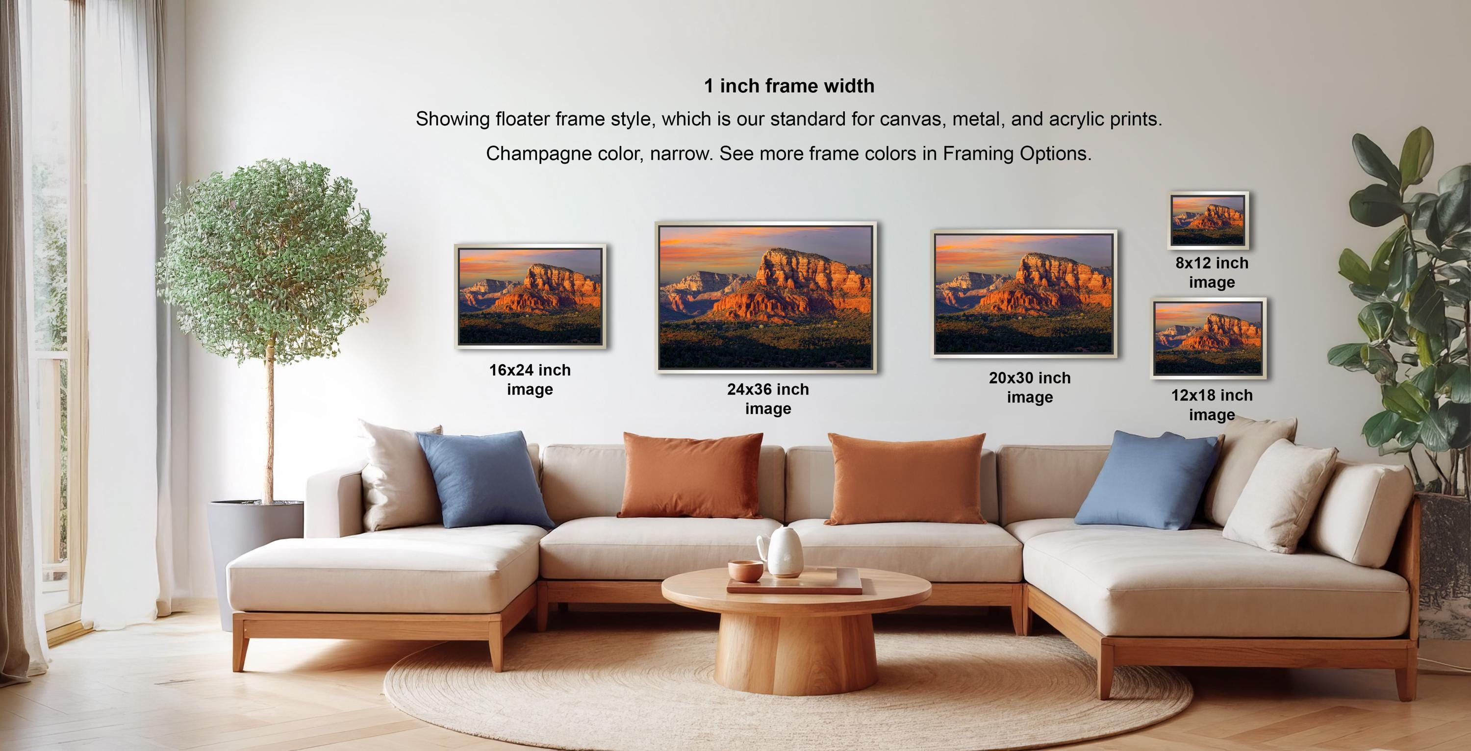 The image is a living room with a large sectional sofa and a coffee table. There are four framed landscape photographs of mountains displayed on the wall, each with a different frame size ranging from 16.26 to 20.30 inches. The photographs are arranged in a grid-like pattern, showcasing the different frame widths.