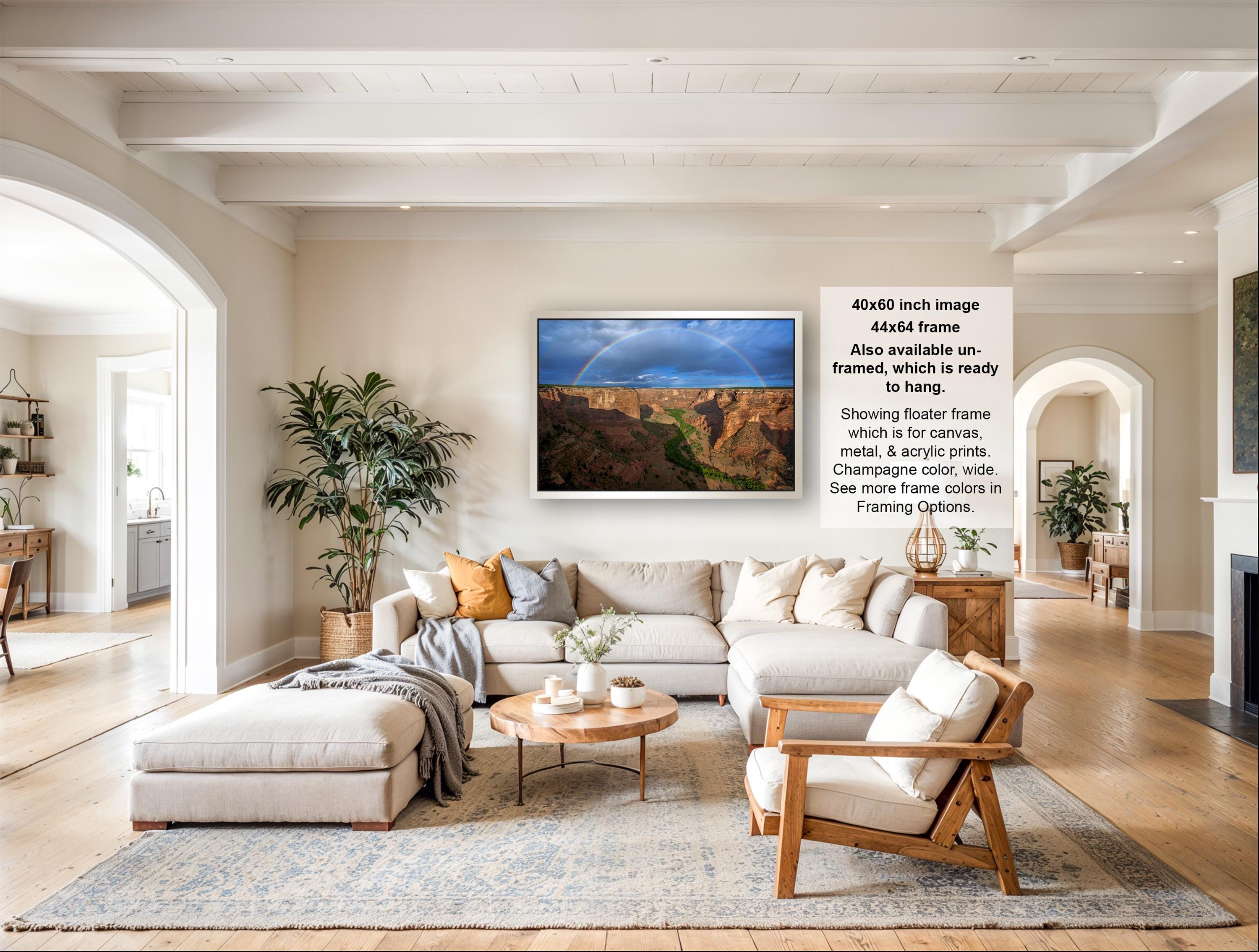 The image is a large framed photograph of a canyon landscape, hanging on a wall in a living room.