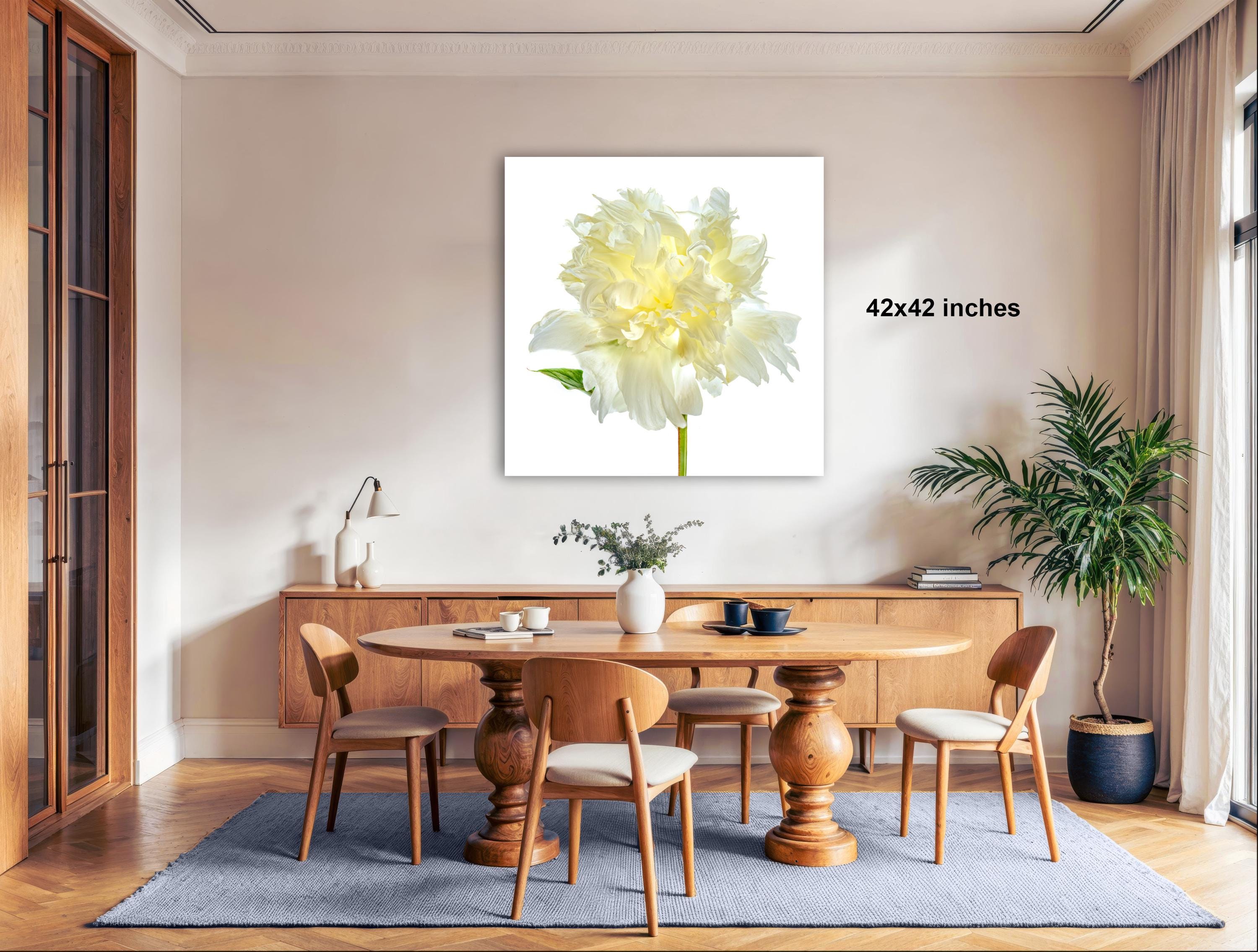 a dining room with a large, white flower on the wall as the focal point. The room has a wooden dining table surrounded by wooden chairs, and there are potted plants and other decorative elements in the space.