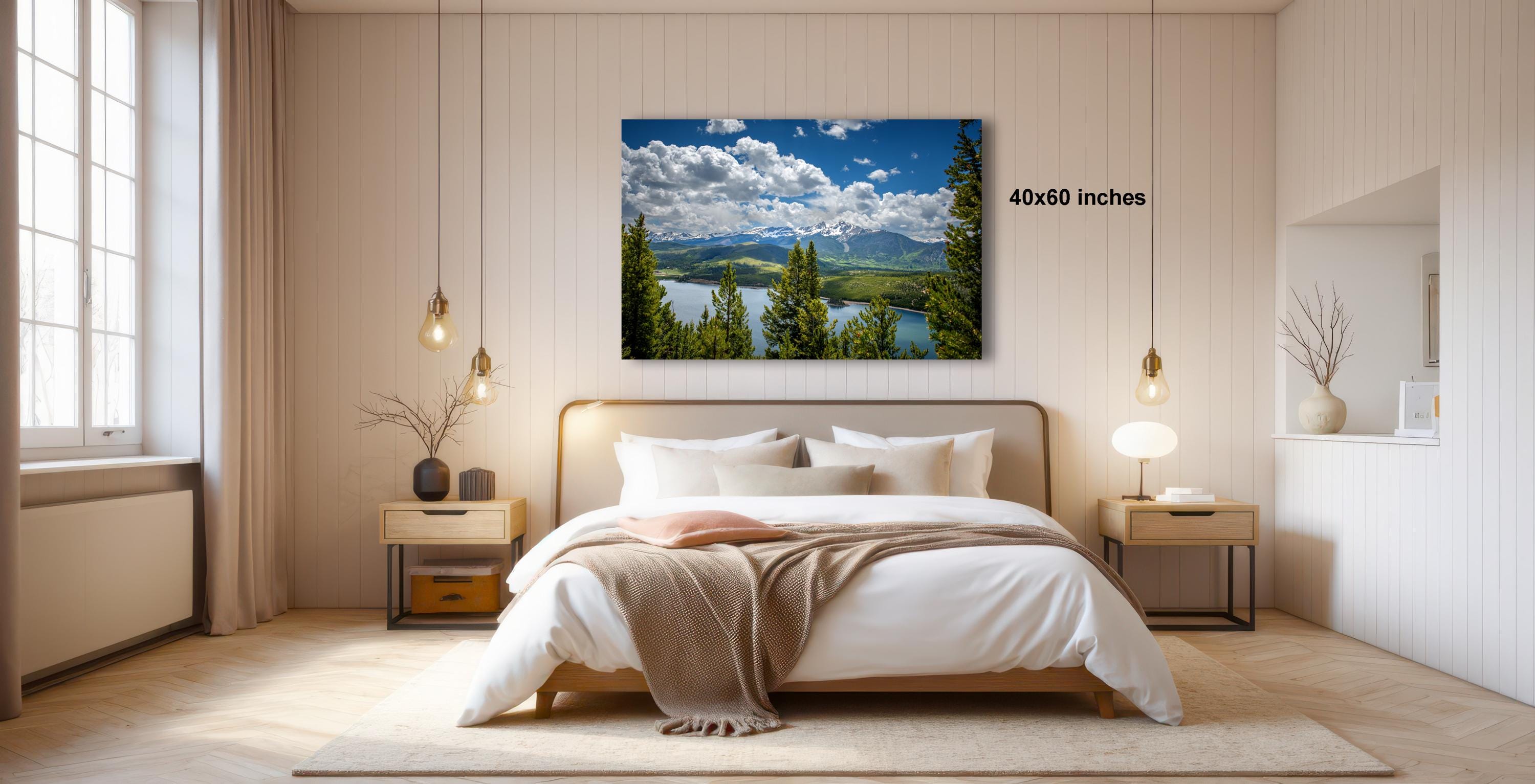 a serene bedroom with a large bed, wooden furniture, and a framed landscape photograph hanging on the wall.