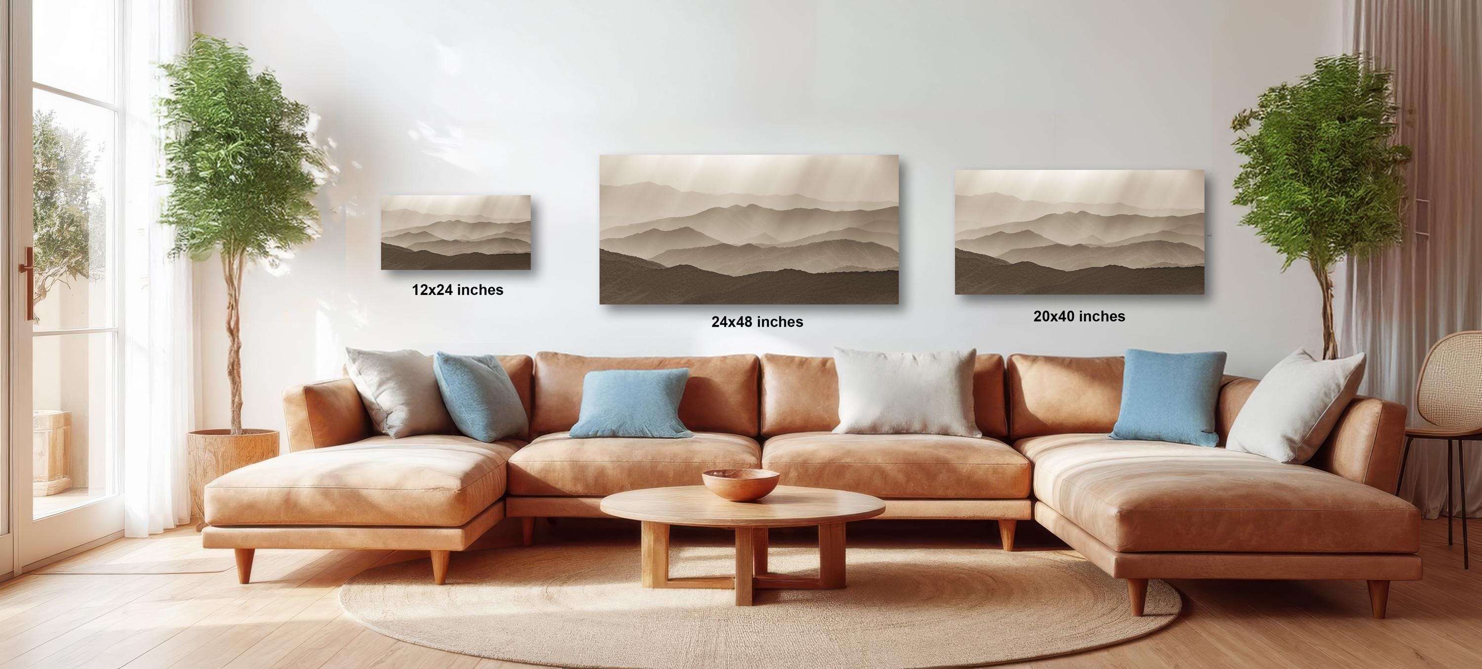a cozy living room with a large sectional sofa, a coffee table, and three landscape paintings hanging on the wall.