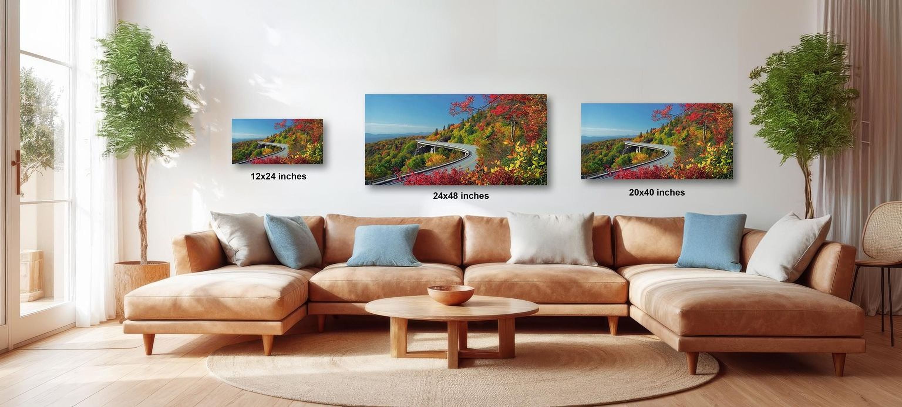 A cozy living room with a large sectional sofa, a coffee table, and three framed landscape photographs of a winding road through a forest.