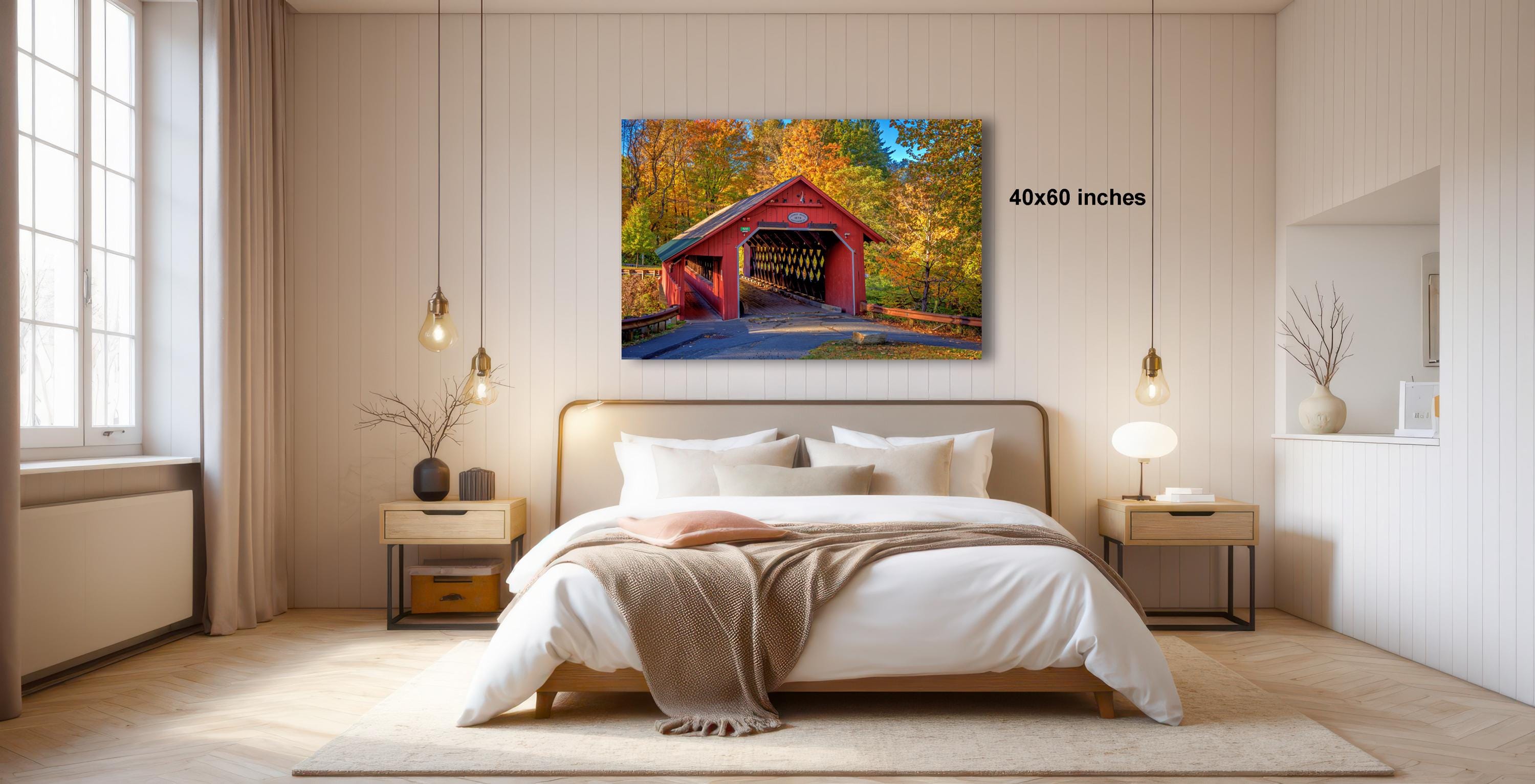 a bedroom with a large bed, a nightstand, and a painting of a red covered bridge hanging on the wall.