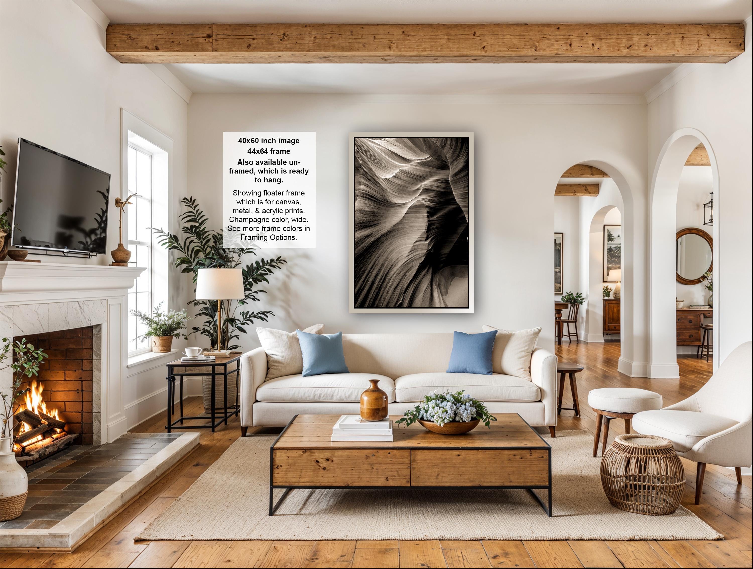 a cozy living room with a fireplace, a large framed abstract painting on the wall, a white sofa, a coffee table, and various decorative elements such as potted plants and vases.