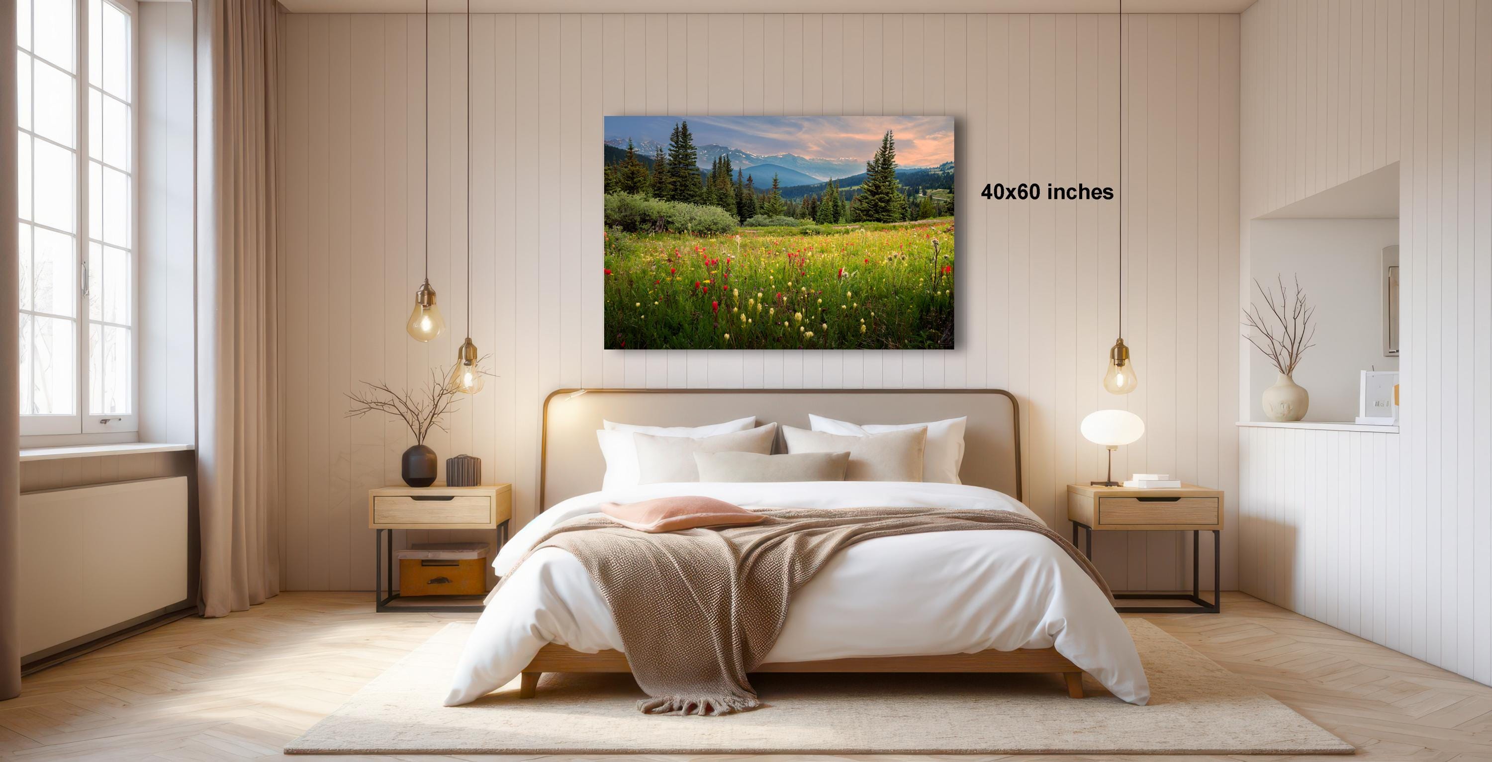 a serene bedroom with a large bed, wooden furniture, and a painting of a field of flowers hanging above it.
