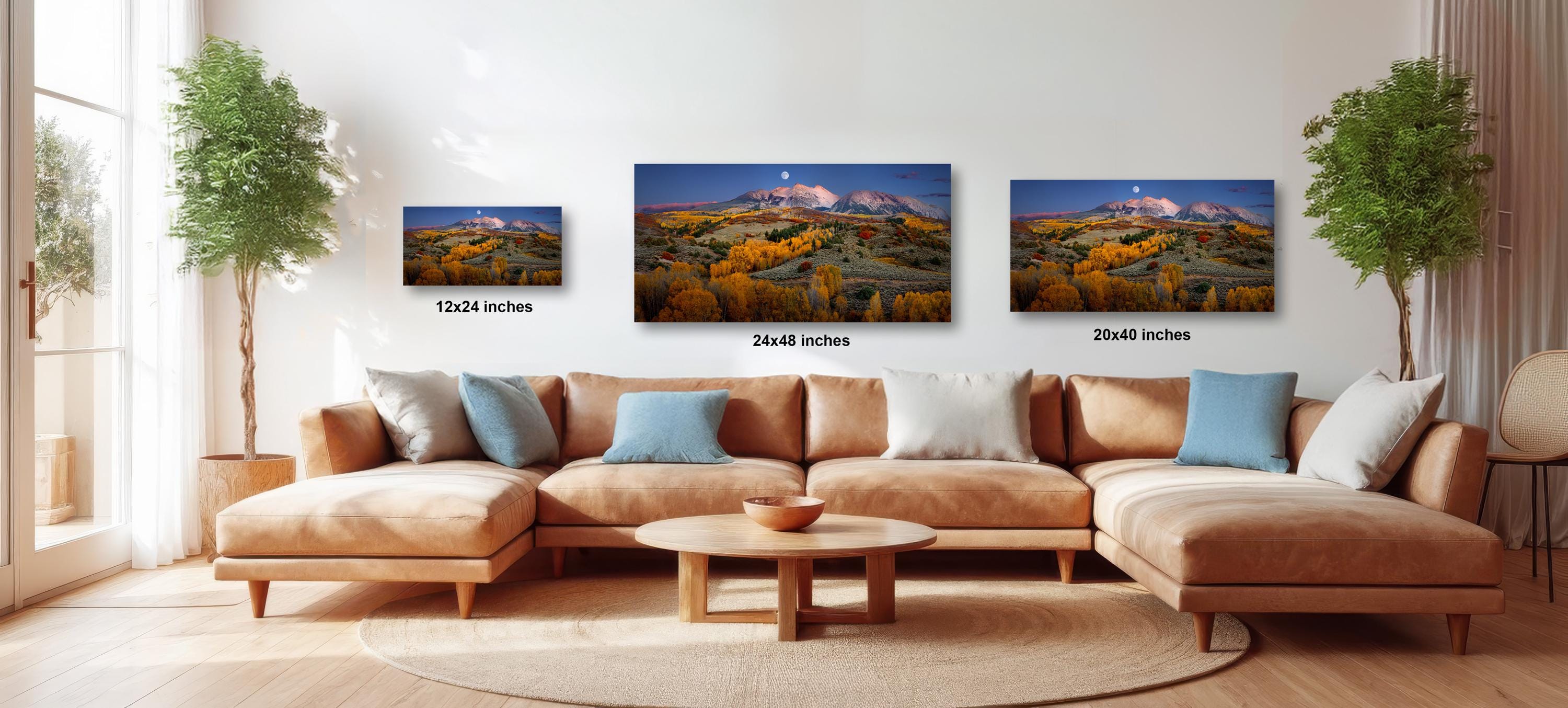 The image is a modern living room with a large sectional sofa, a coffee table, and three framed landscape photographs hanging on the wall.