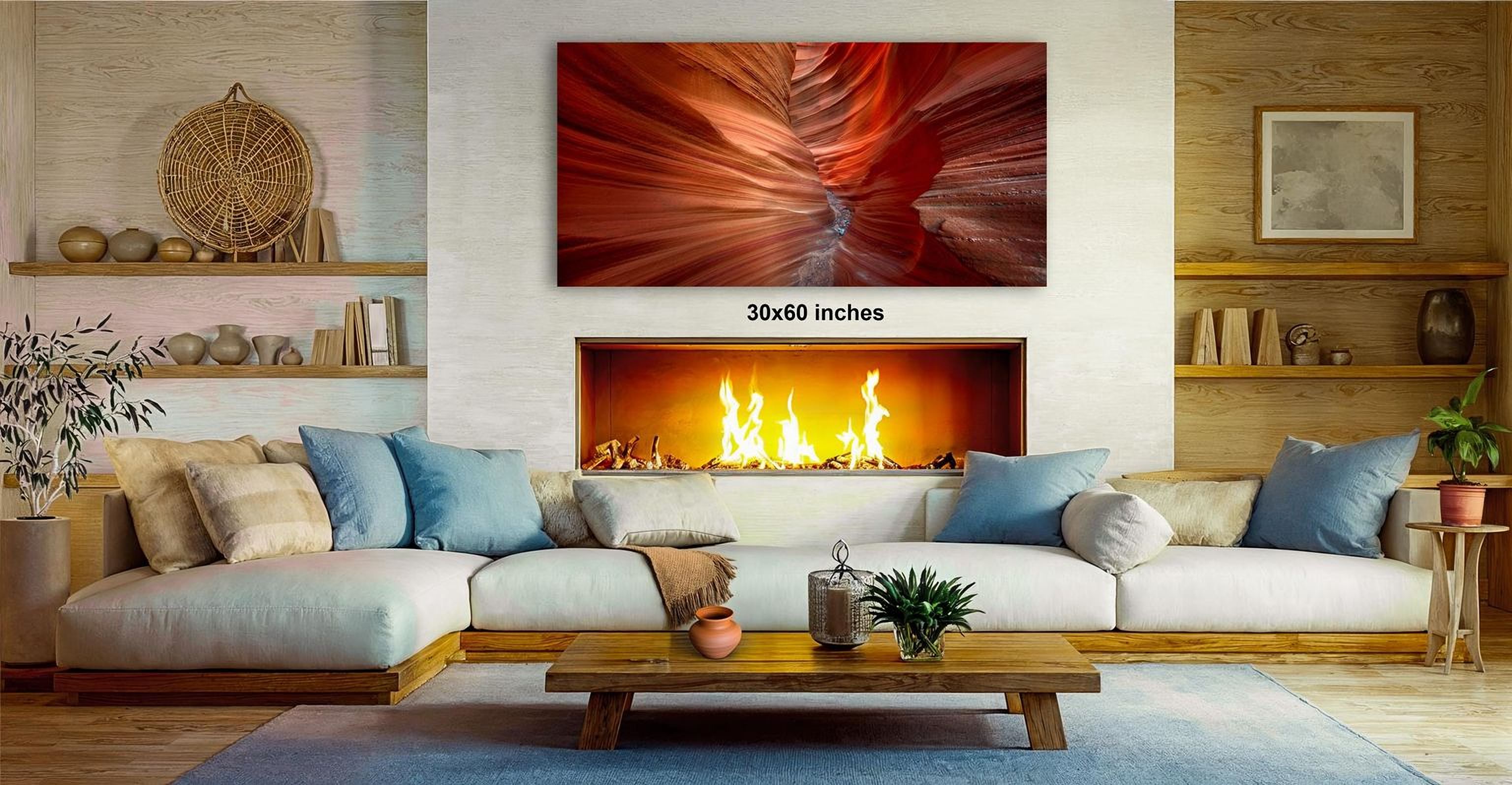 a cozy living room with a fireplace, a large framed photograph of a canyon, and a wooden coffee table.