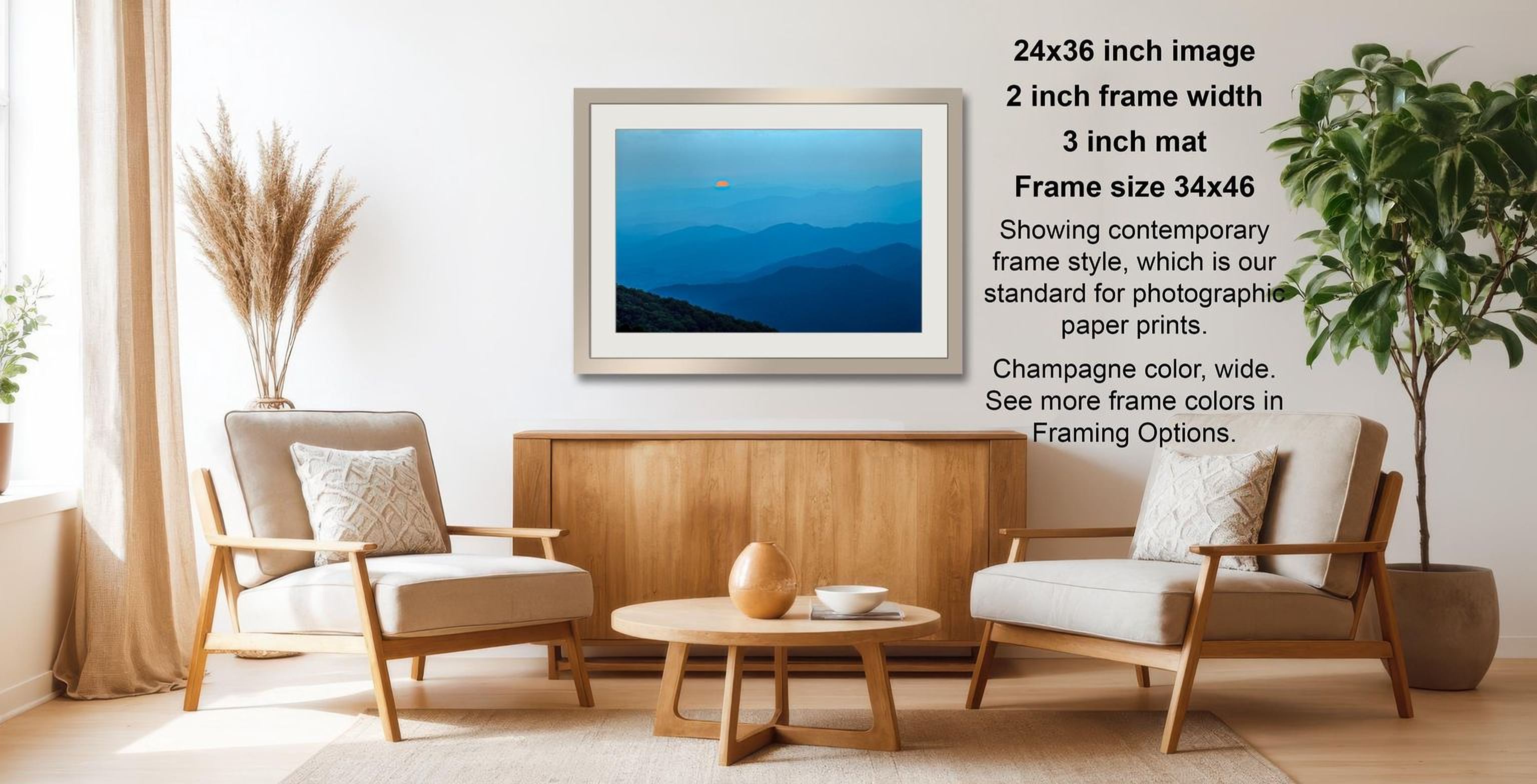 a living room with a framed landscape photograph hanging on the wall, a wooden coffee table in the center, and two white armchairs facing each other.