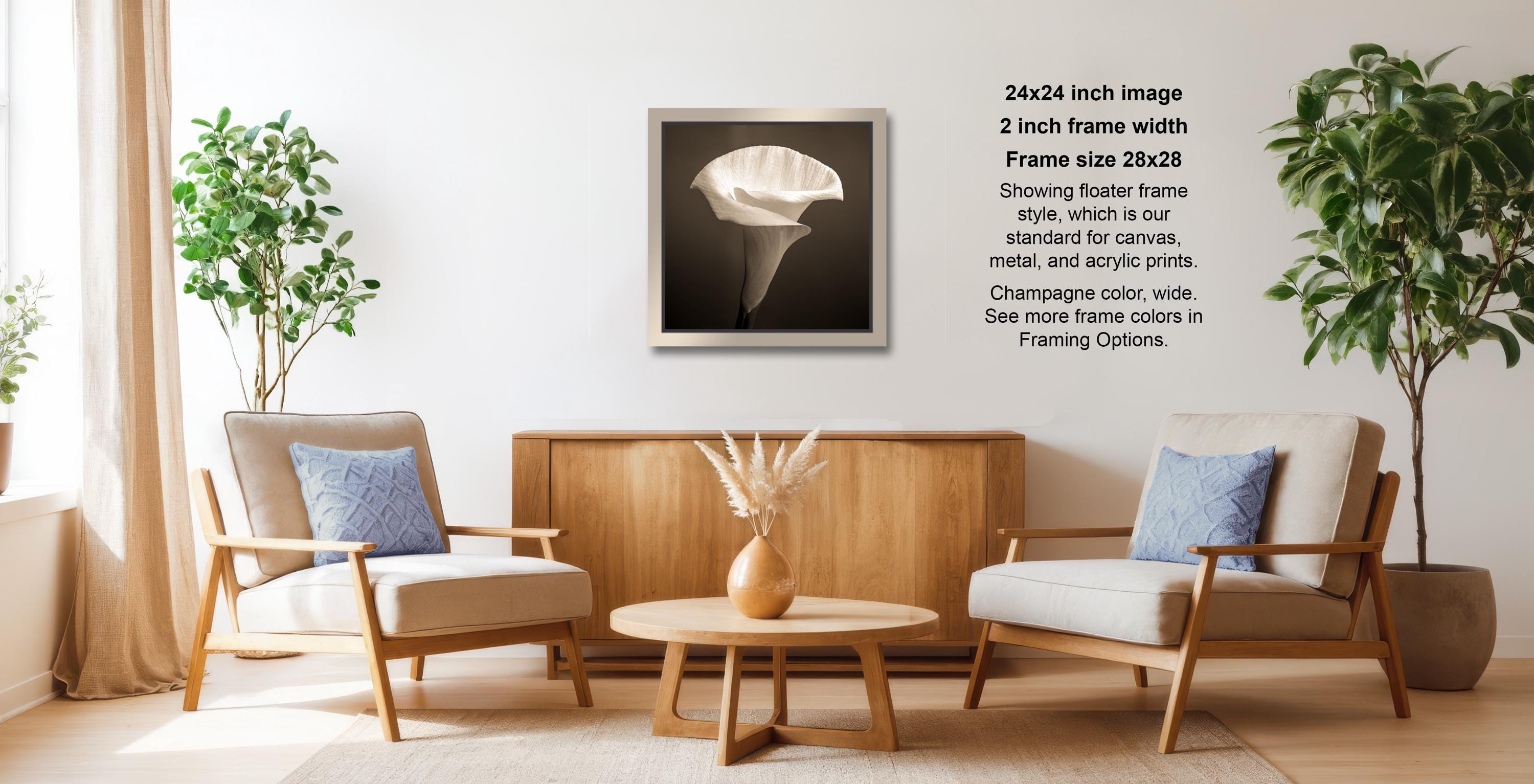 a cozy living room with two beige armchairs, a wooden coffee table, and a framed black and white photograph of a flower on the wall.