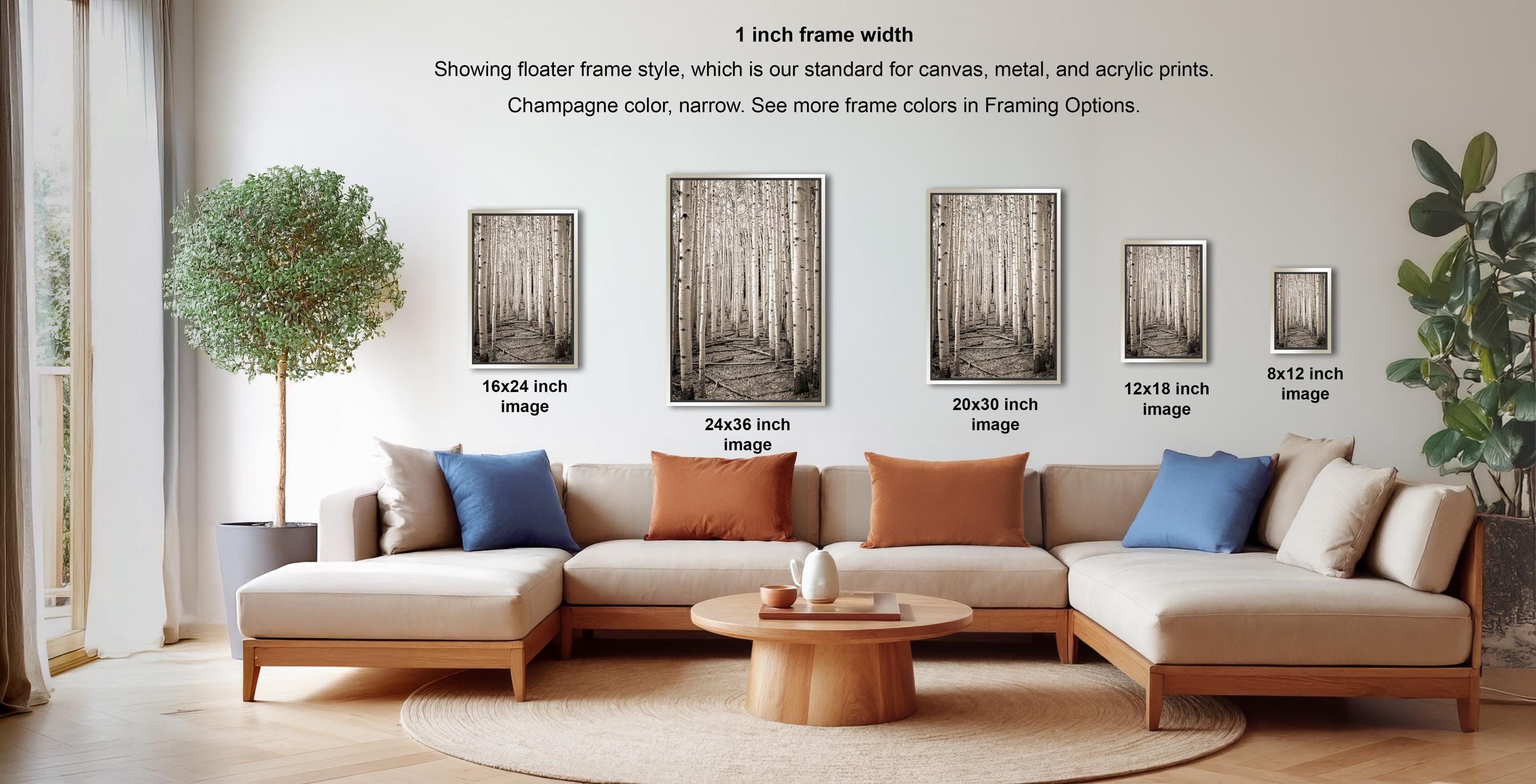 a living room with a large sectional sofa, a coffee table, and various framed artworks displayed on the wall.