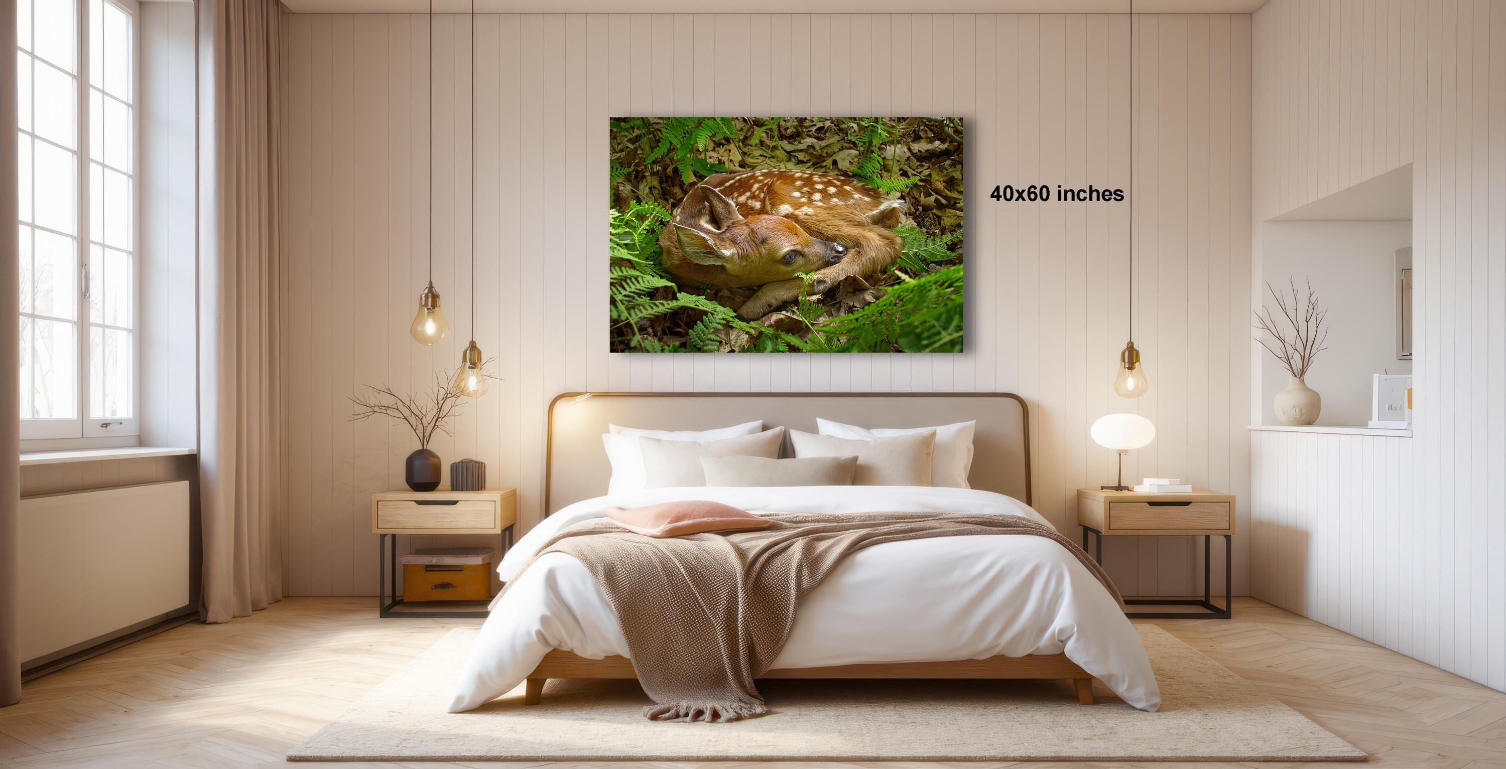 a serene bedroom scene with a large bed, a nightstand, and a painting of a deer resting in the grass.