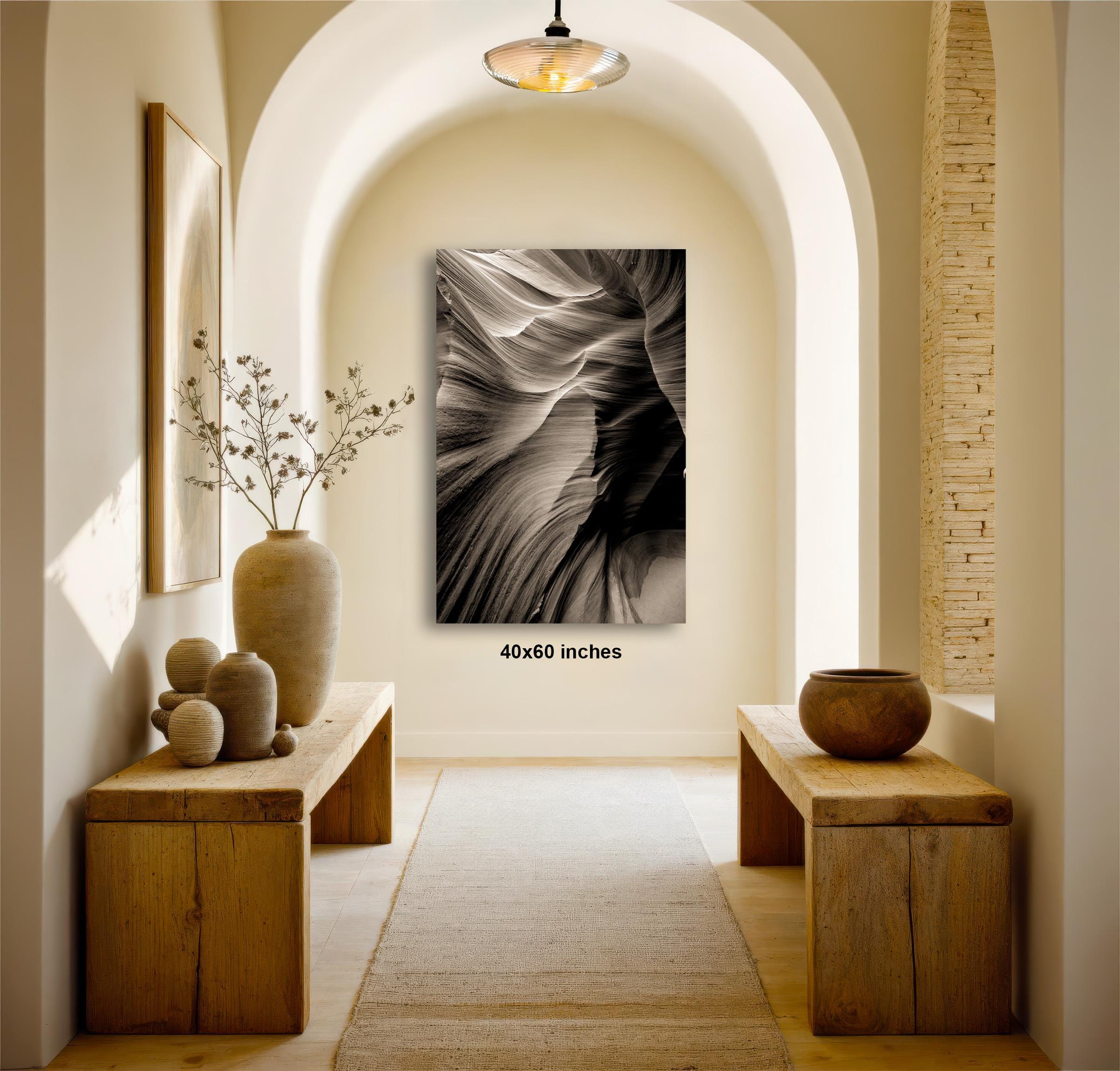 a hallway with a large black and white photograph hanging on the wall, flanked by two wooden benches. The hallway is decorated with various objects, including a vase, a bowl, and a plant, creating a serene and inviting atmosphere.