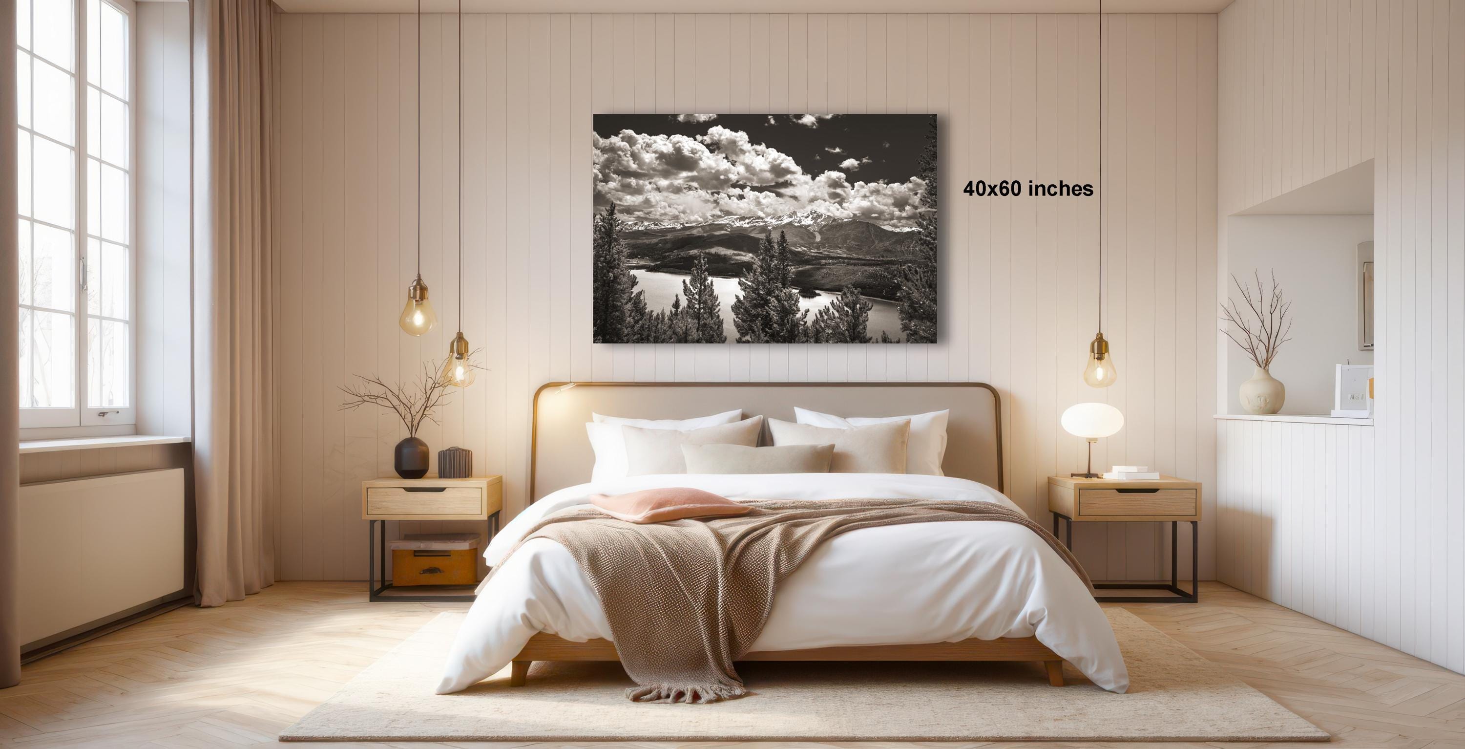 a serene bedroom with a large bed, wooden furniture, and a large black and white landscape photograph hanging on the wall.