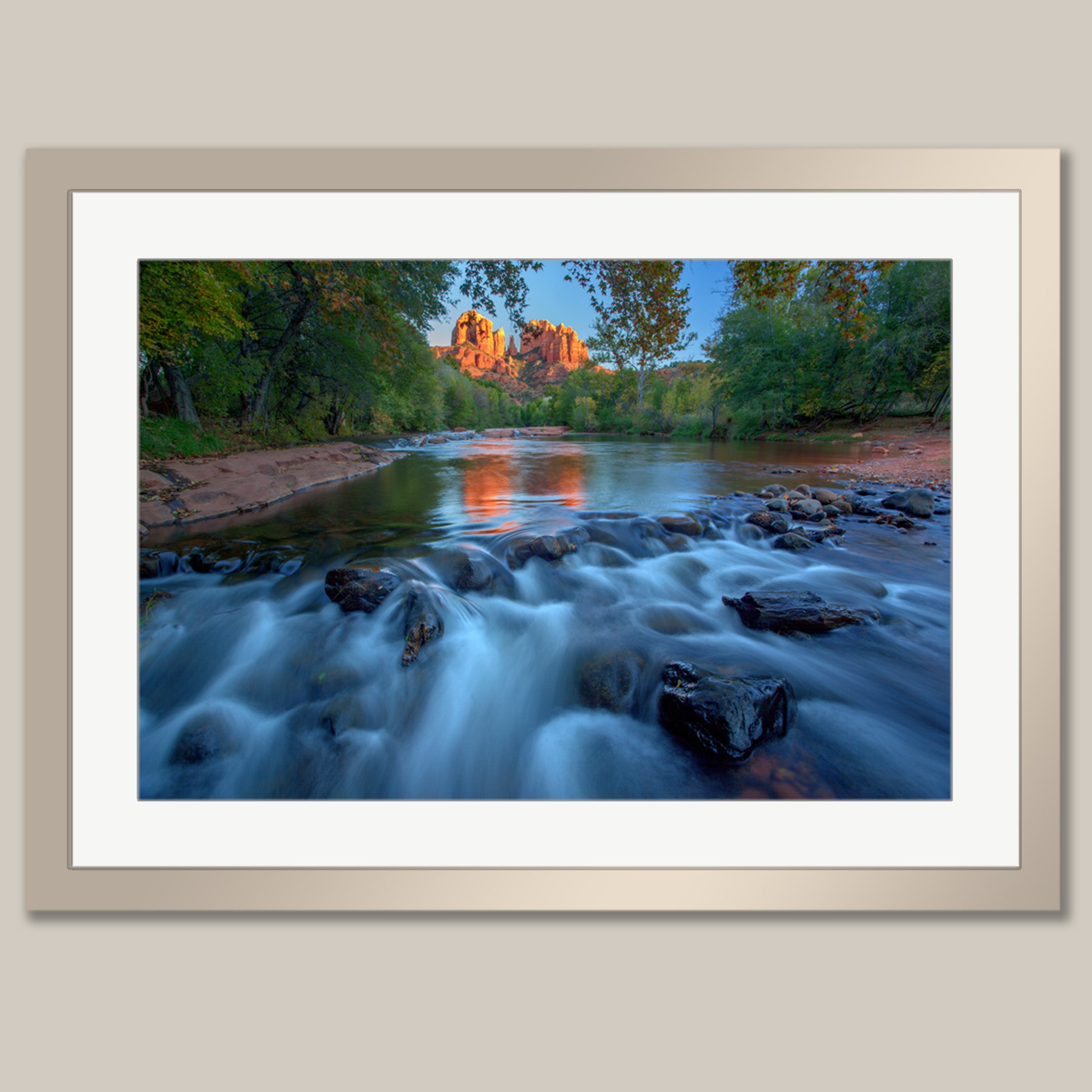A framed photograph depicting a serene river flowing through a lush, forested landscape, with a large rock formation visible in the distance.