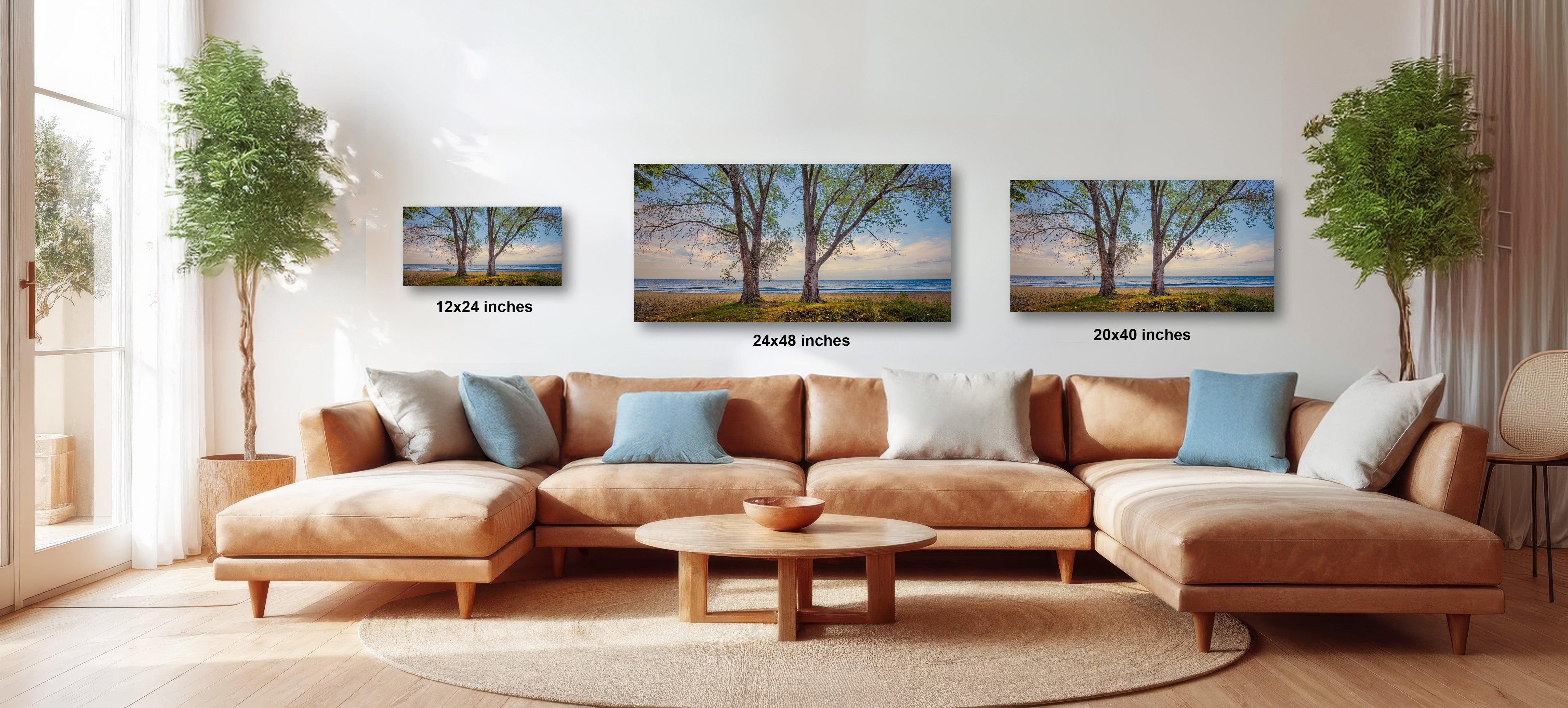 A cozy living room with a large sectional sofa, a coffee table, and three framed landscape paintings hanging on the wall.