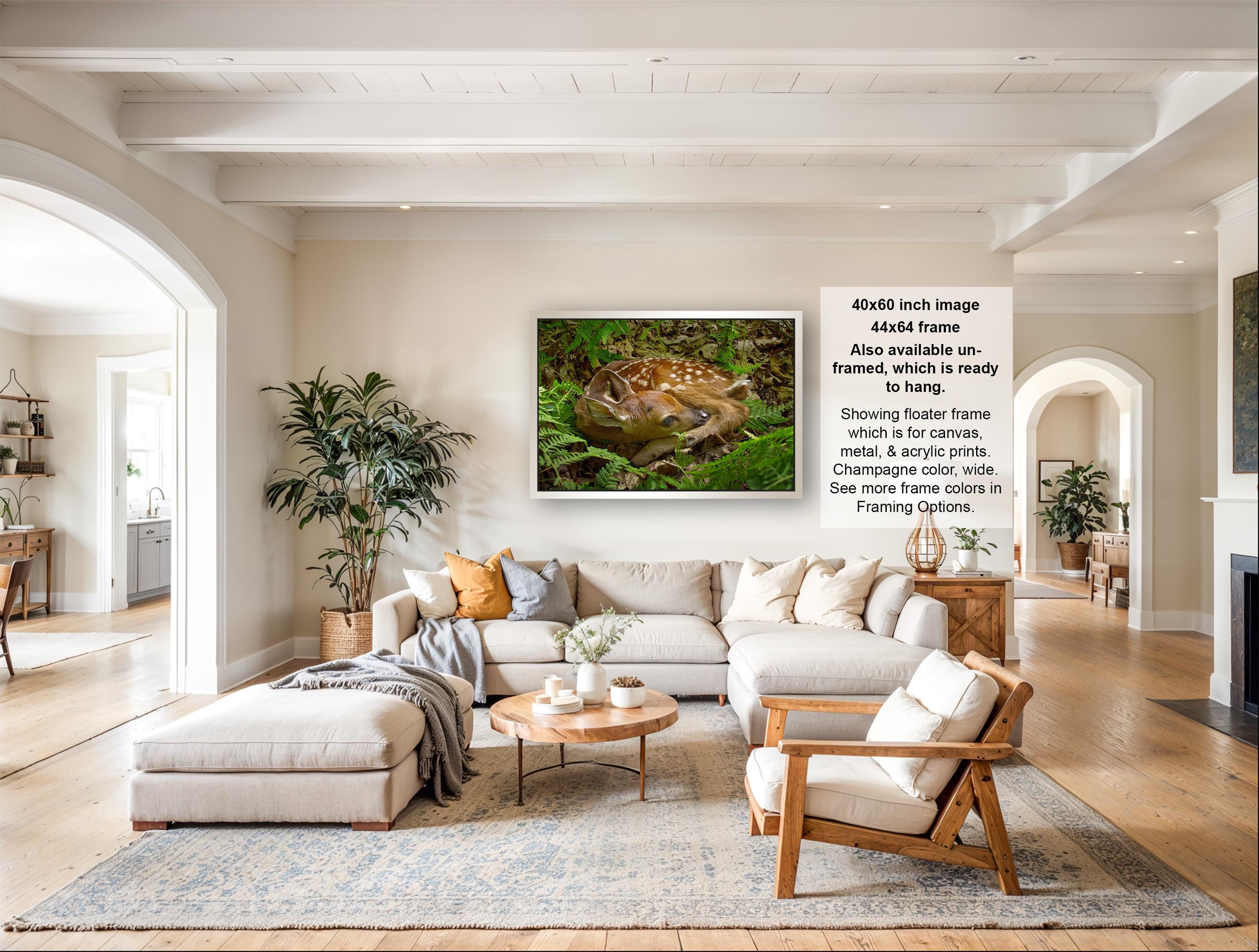 The image is a living room with a large sectional sofa, a coffee table, and a fireplace. There are also several potted plants and decorative items in the room.
