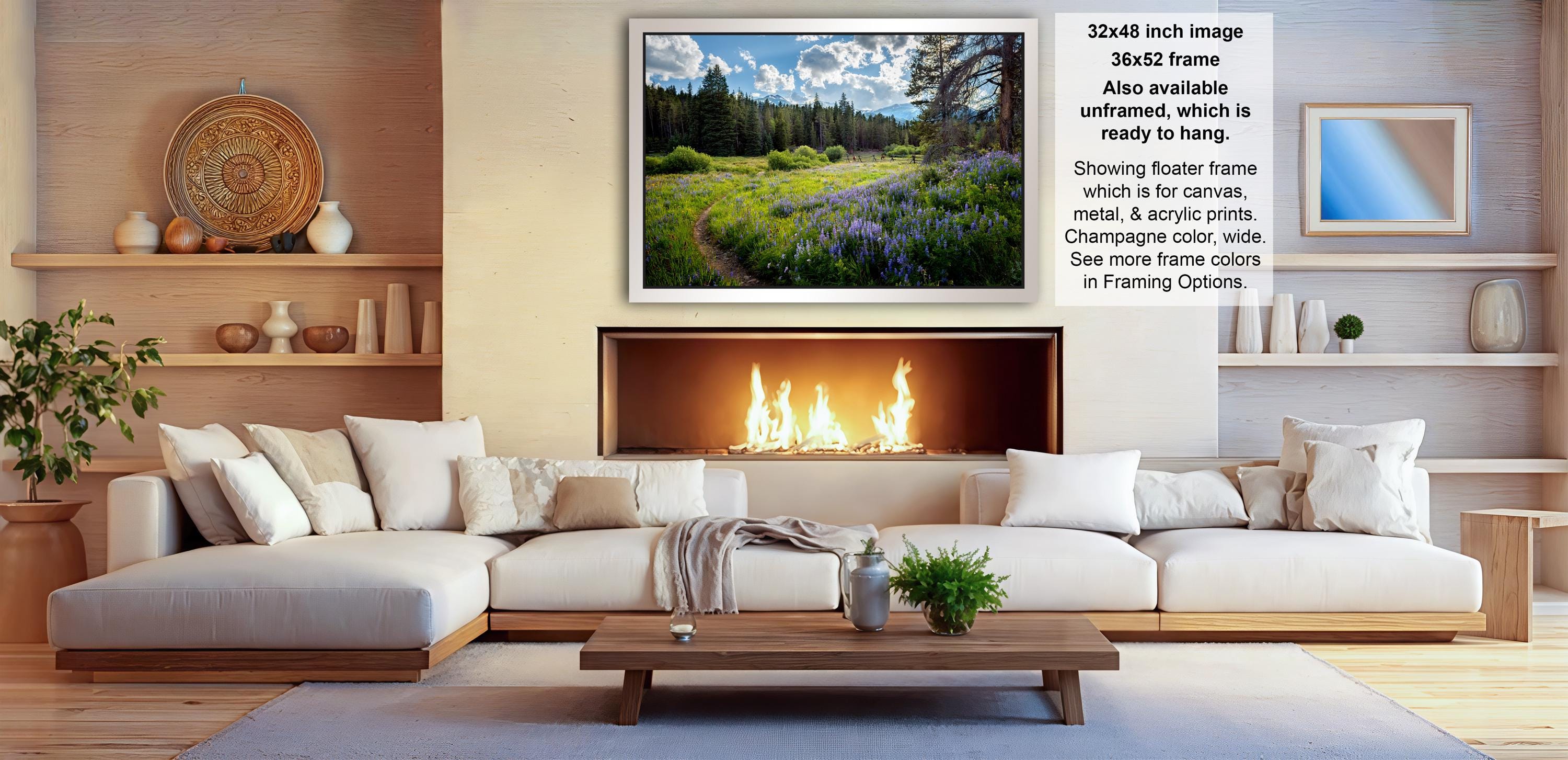 a cozy living room with a fireplace, white sofas, and a coffee table. The room has a warm and inviting atmosphere, with a fireplace providing a focal point and a painting of a field of flowers hanging above it. The furniture and decor create a harmonious and comfortable space for relaxation and socializing.