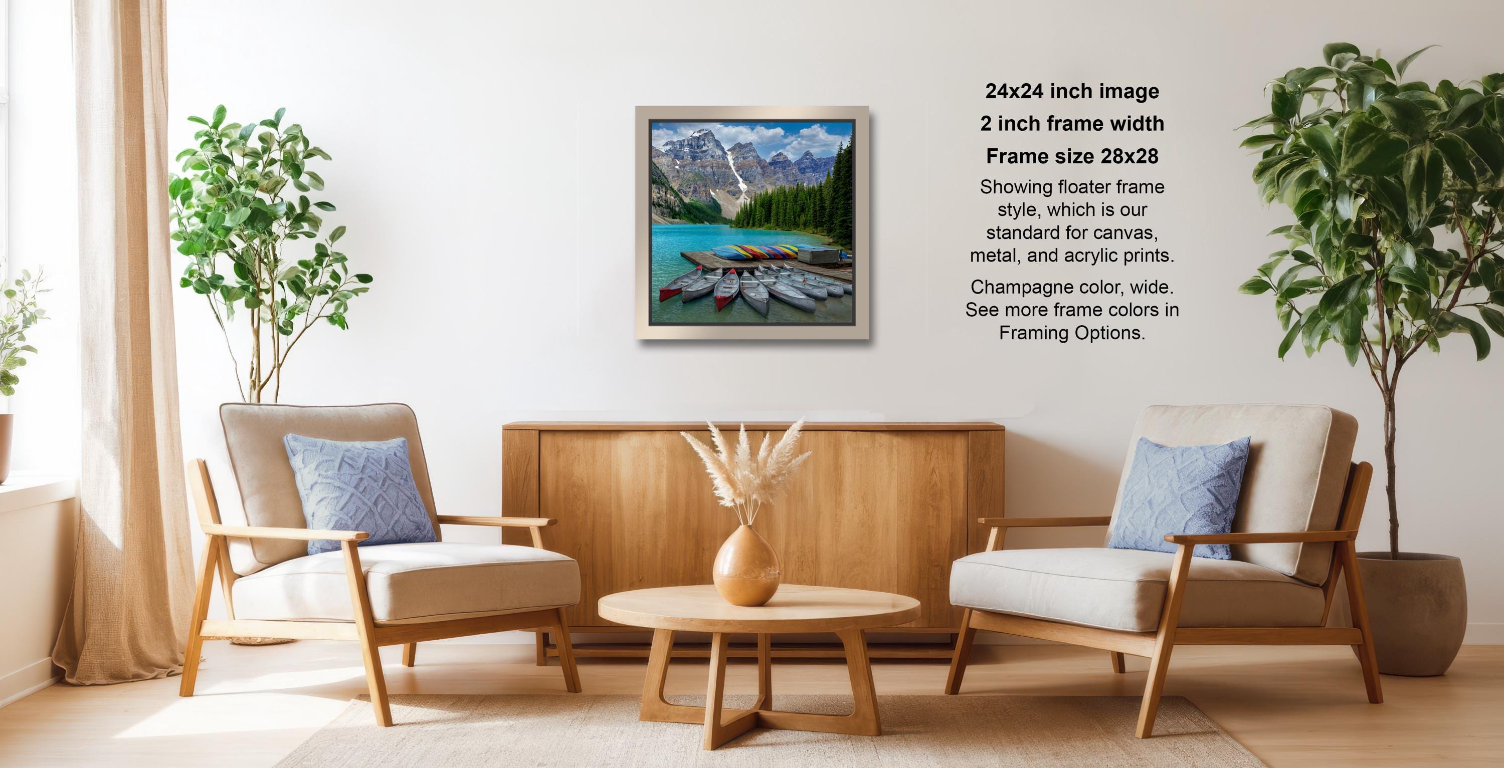 a cozy living room with a wooden coffee table, two beige armchairs, and a framed landscape painting hanging on the wall.