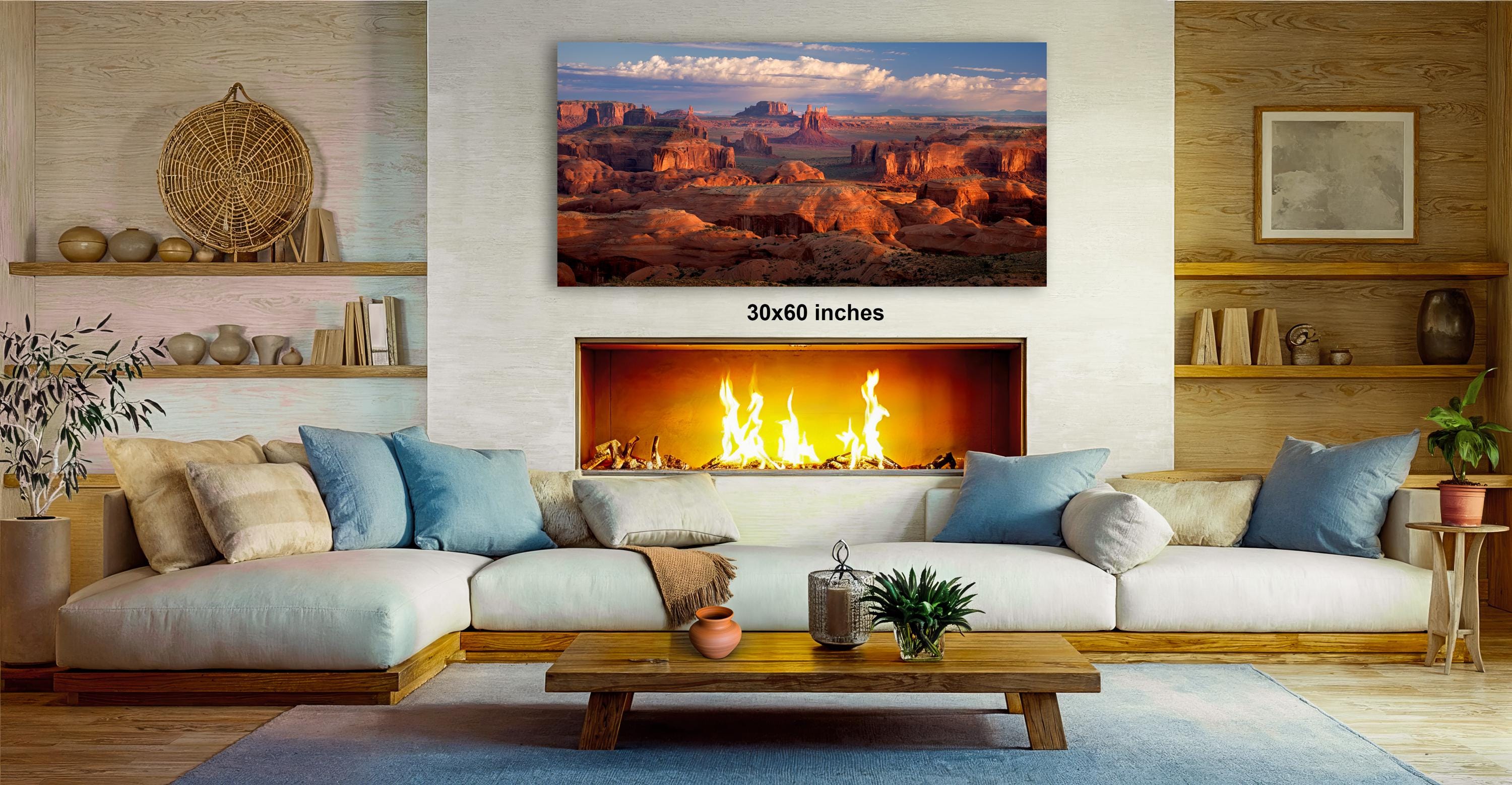 a cozy living room with a fireplace, a large framed landscape photograph hanging on the wall, and a wooden coffee table in front of the fireplace.