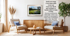 a living room with a framed landscape photograph hanging on the wall, a wooden coffee table in the center, and two armchairs facing each other.