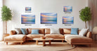 The image is a modern living room with a large sectional sofa, a coffee table, and several potted plants. The wall is decorated with three framed landscape paintings, each varying in size and depicting different scenes. The paintings are arranged in a grid-like pattern, with the largest one at the top and the smallest at the bottom.
