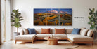 a large, colorful landscape painting hanging on a wall in a living room.
