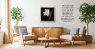 a cozy living room with two beige armchairs, a wooden coffee table, and a framed black and white photograph of a flower on the wall.