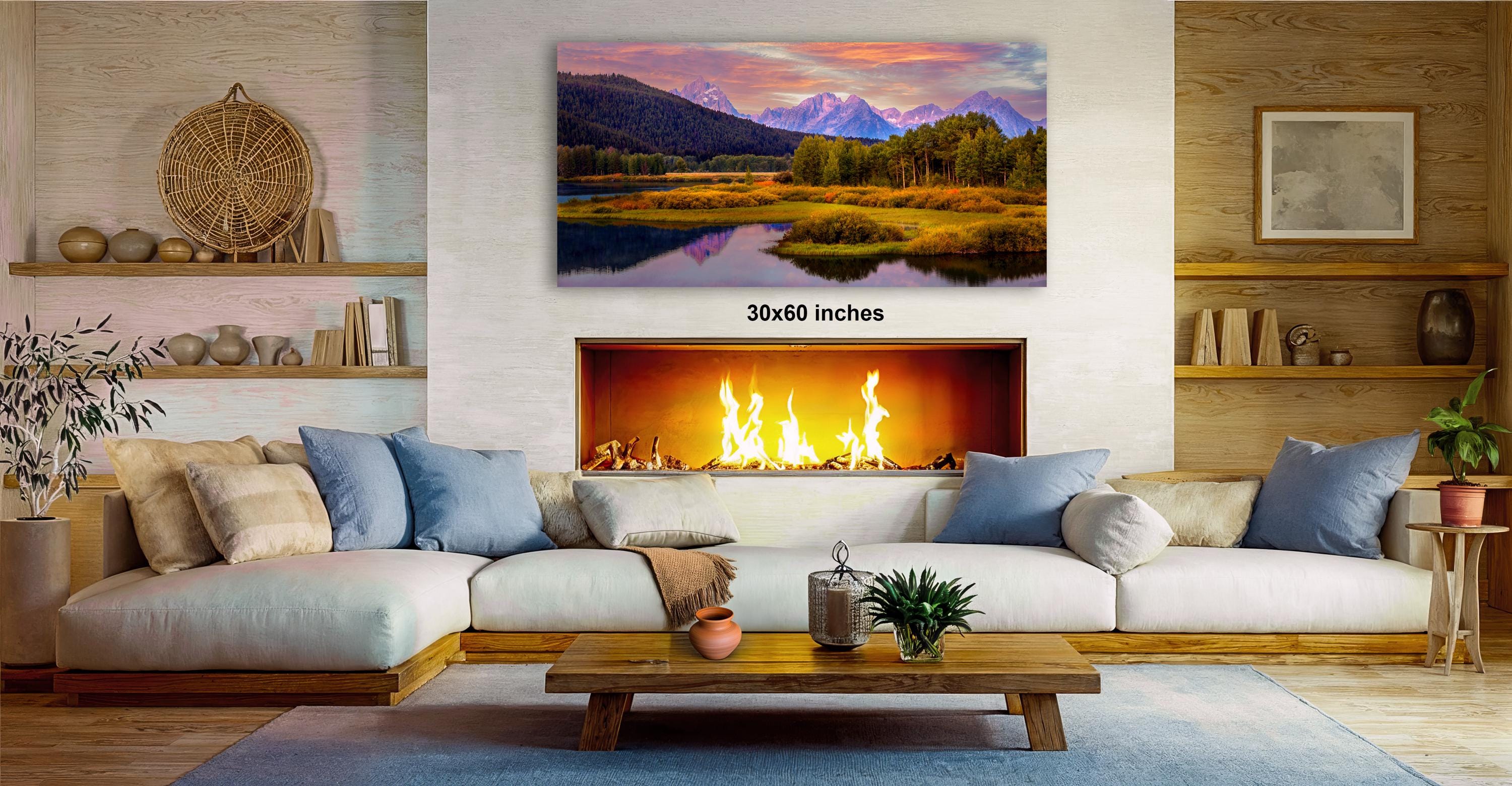 a cozy living room with a fireplace, a large landscape painting hanging on the wall, and a wooden coffee table in front of the fireplace.