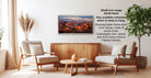 a living room with a wooden coffee table, two white armchairs, and a framed landscape painting hanging on the wall.