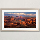 a breathtaking view of a desert landscape with towering red rock formations and a vast expanse of sky.