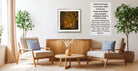 a cozy living room with a wooden coffee table, two beige armchairs, and a framed photograph of a tree-lined path. The photograph is framed in a modern style and is hanging on the wall.