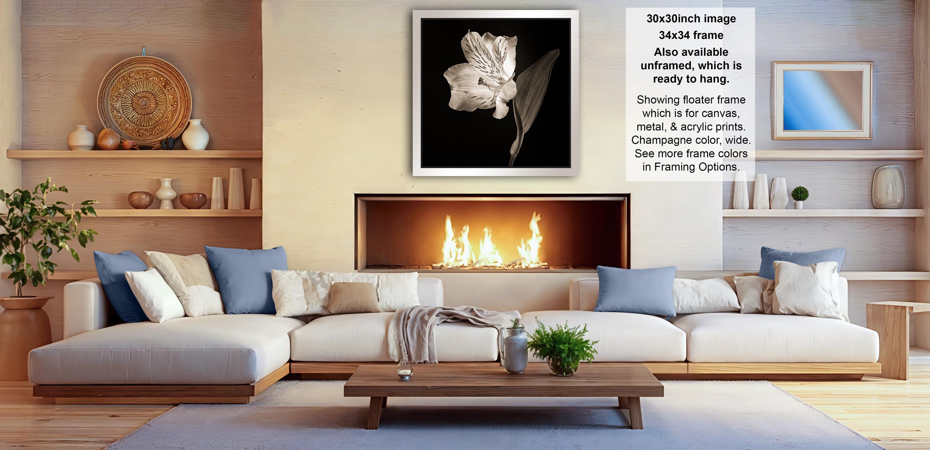 The image is a modern living room with a fireplace, white sofas, and various decorative elements such as vases and a potted plant.