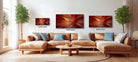 a modern living room with a large sectional sofa, a coffee table, and three framed photographs of abstract landscapes hanging on the wall.