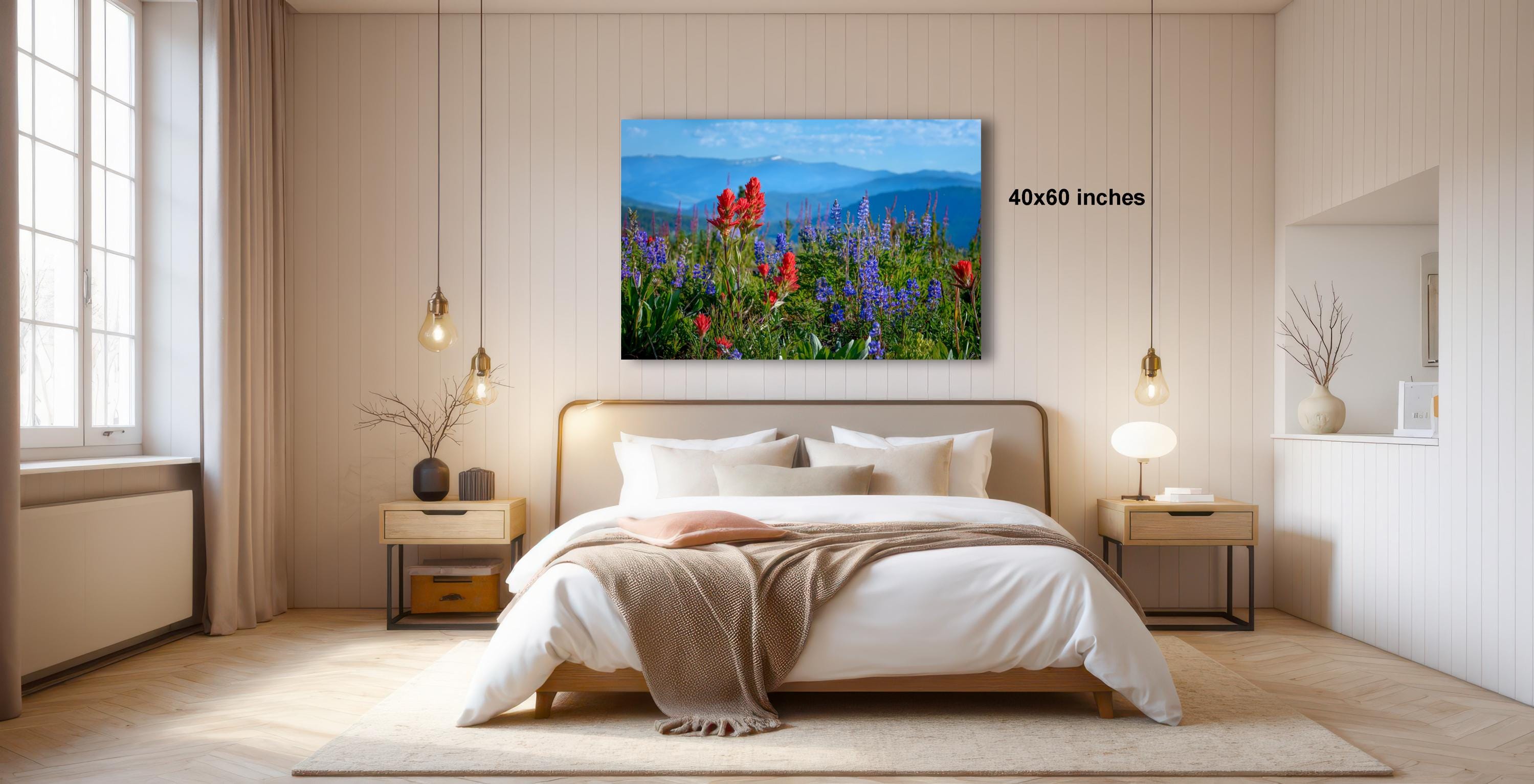 a serene bedroom with a large bed, wooden nightstands, and a painting of a field of wildflowers hanging above it.