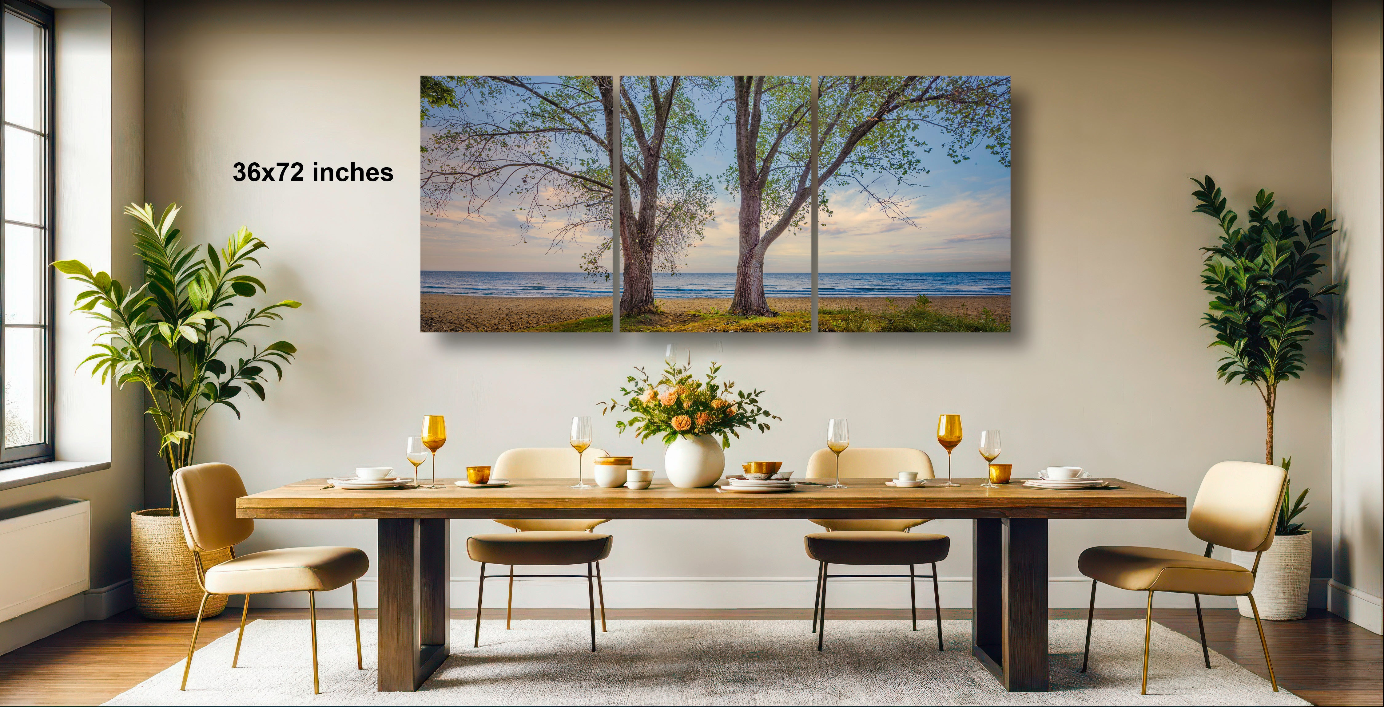 a dining room with a large wooden table set for four, surrounded by four chairs. Above the table, there is a large painting depicting a beach scene with trees and the ocean. The painting is framed and hangs on the wall, creating a serene and inviting atmosphere in the room.