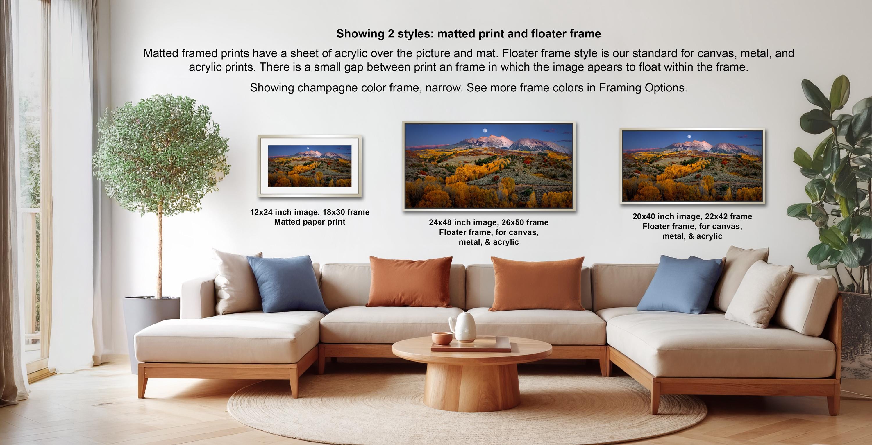 three framed prints of a mountainous landscape, each with a different frame style and size, displayed in a living room setting with a sofa and a coffee table.