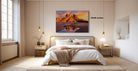a serene bedroom with a large bed, a nightstand, and a painting of a desert landscape hanging on the wall.