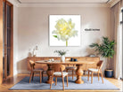 a dining room with a large, white flower on the wall as the focal point. The room has a wooden dining table surrounded by wooden chairs, and there are potted plants and other decorative elements in the space.