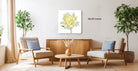 a living room with two beige armchairs, a wooden coffee table, and a large white flower on the wall.