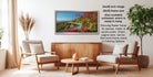 The image is a living room with a large framed landscape photograph hanging on the wall, featuring a winding road surrounded by trees and foliage. The room is furnished with two chairs and a coffee table, creating a cozy and inviting atmosphere.