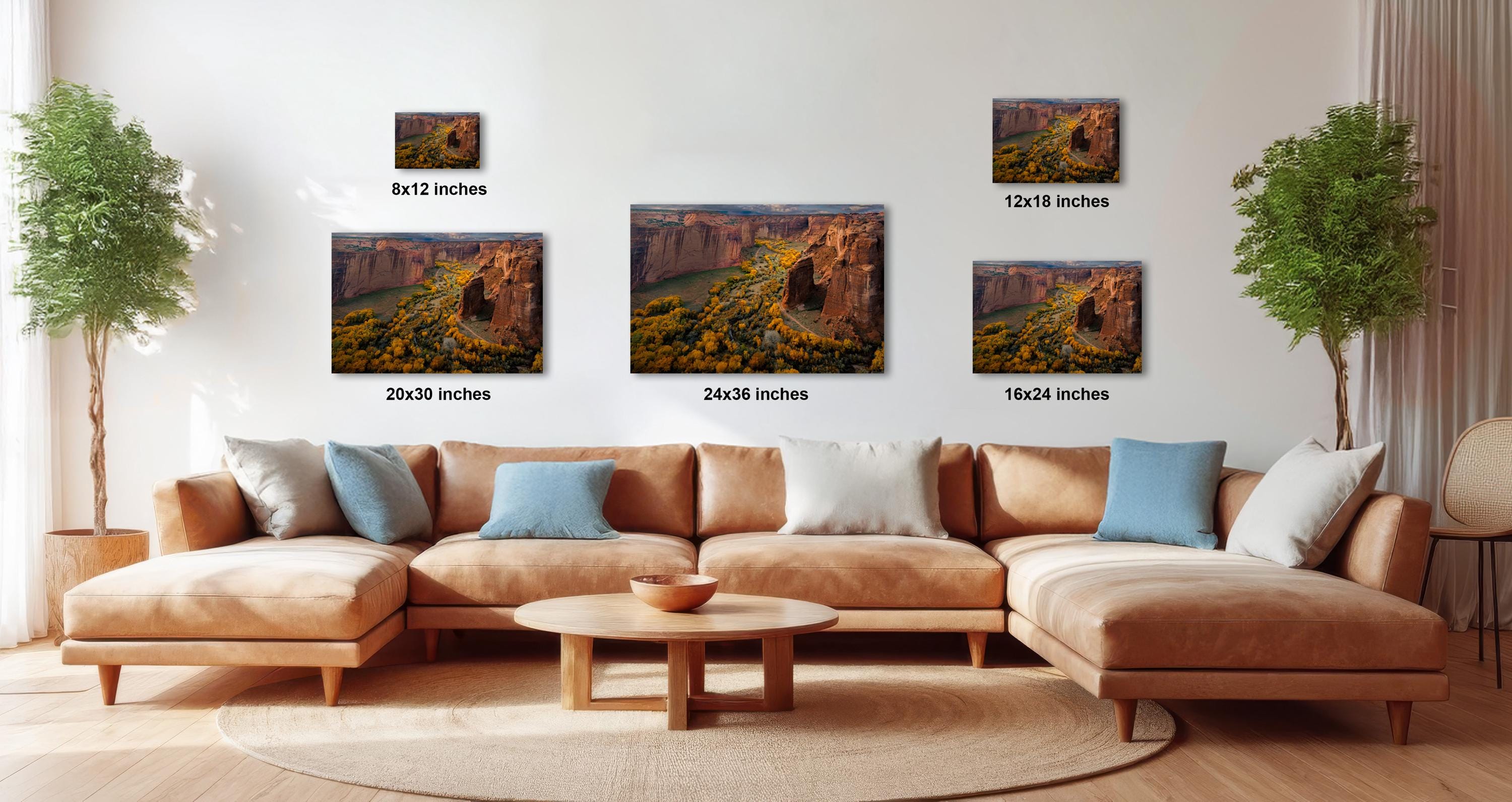 a living room with a large sectional sofa, a coffee table, and several framed landscape photographs displayed on the wall.