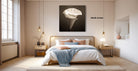 A modern bedroom with a large bed, wooden furniture, and a large framed artwork of a white flower on the wall.