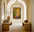 a serene hallway with a wooden bench on the left side and a wooden bench on the right side. Above the benches, there is a large painting of a forest path with autumn foliage. The painting is framed and hangs on the wall, adding a touch of nature and color to the otherwise neutral-toned hallway.