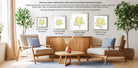 a living room with three framed pictures of flowers on the wall, two of which are mat-framed and one of which is a flat-framed print. The room is decorated with potted plants and a wooden coffee table, creating a cozy and inviting atmosphere.