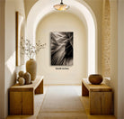 a hallway with a wooden floor, arched doorways, and two wooden benches. On the walls, there are two vases and a painting. The painting is a black and white image of a wave. The hallway has a warm, inviting atmosphere with natural light coming in from the windows.