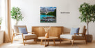 a living room with a large painting of a mountain lake hanging on the wall, surrounded by two chairs and a coffee table.