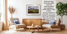 The image is a living room with a framed landscape painting hanging on the wall, a wooden coffee table in the center, and two chairs facing each other.